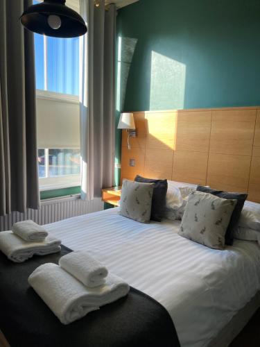 a bedroom with a large bed with towels on it at The Bell Inn, Rickinghall in Rickinghall