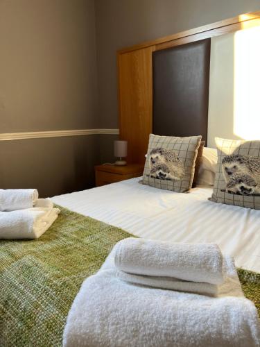 a bedroom with a bed with two towels on it at The Bell Inn, Rickinghall in Rickinghall