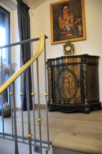 a clock on a cabinet in a room with a painting at Genio 7A in Palanga