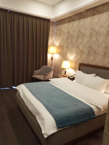 A bed or beds in a room at Macara Sheki City Hotel
