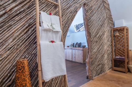 a room with a wall made out of wood and towels at Mamamapambo Boutique Hotel in Jambiani