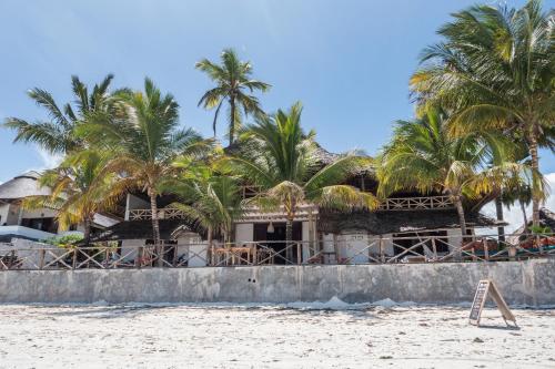 a resort on the beach with palm trees at Mamamapambo Boutique Hotel in Jambiani