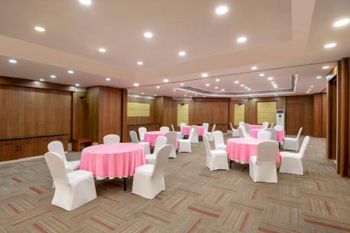 a banquet hall with pink tables and white chairs at Radisson Blu Kaushambi Delhi NCR in Ghaziabad