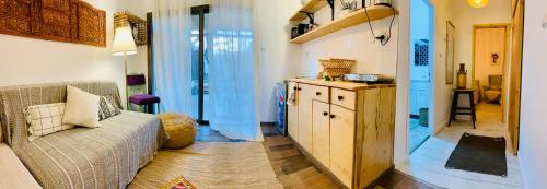een woonkamer met een bank en een keuken bij Soof Boutique apartment in Eilat