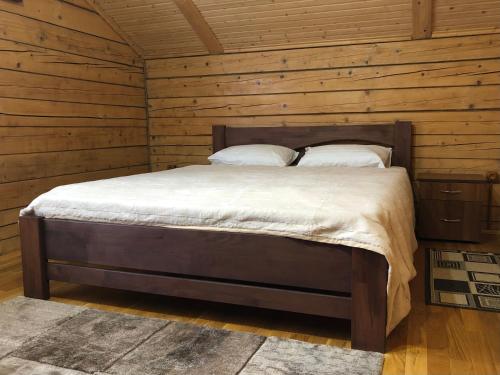 a bedroom with a bed in a wooden cabin at Вербовий двір - Willow Yard in Zhdenievo