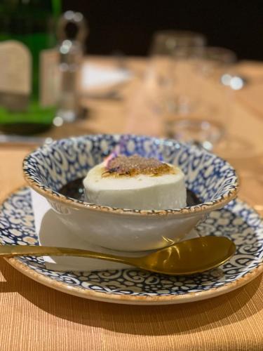 a dessert in a bowl on a plate with a spoon at Gran Paradiso Hotel Spa in San Giovanni Rotondo