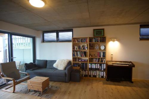 ein Wohnzimmer mit Sofa und Bücherregal in der Unterkunft Apartment im Wanderparadies Siebengebirge in Königswinter