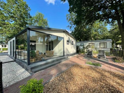 a tiny house with a large glass extension at Casa 2234 op camping de Schatberg in Sevenum