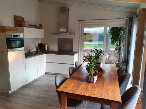 uma cozinha com uma mesa de madeira com uma planta em Casa 2234 op camping de Schatberg em Sevenum