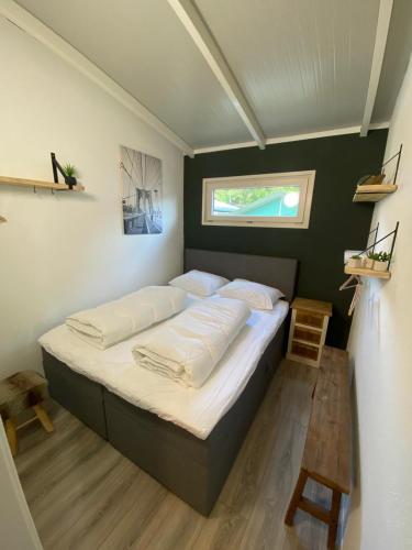 a large bed in a room with a window at Casa 2234 op camping de Schatberg in Sevenum