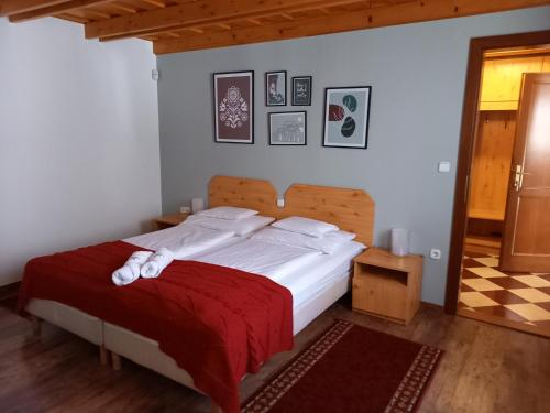 ヴィッラーニにあるBlum Pince - Borozó Vendégházのベッドルーム1室(赤毛布付きの大型ベッド1台付)