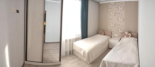a bedroom with two beds and a mirror at Guest House VELVET in Tsaghkadzor