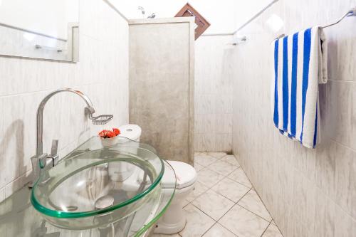 ein Badezimmer mit einem Glaswaschbecken und einem WC in der Unterkunft The Villa Blue Sky in Unawatuna