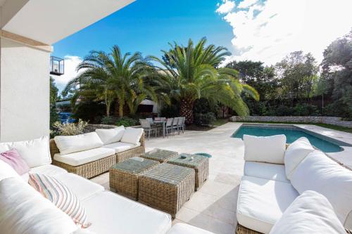d'une terrasse avec des meubles blancs à côté d'une piscine. dans l'établissement Haven of peace in Cap d'Antibes heated swimming pool close to the beaches, à Antibes