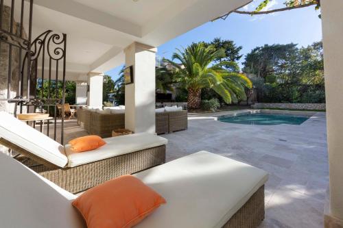 une terrasse avec une piscine et une maison dans l'établissement Haven of peace in Cap d'Antibes heated swimming pool close to the beaches, à Antibes