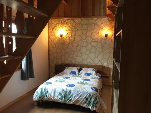 una camera da letto con un letto con fiori blu sopra di Le chalet a Saint-Quentin-Lamotte-Croix-au-Bailly