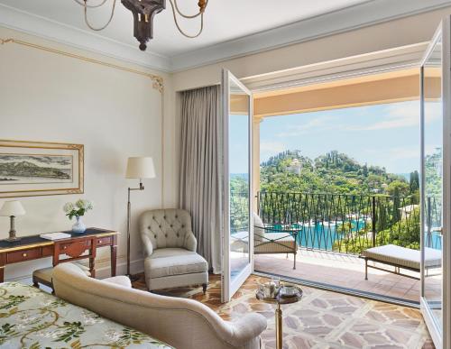 a living room with a large glass door leading to a balcony at Splendido, A Belmond Hotel, Portofino in Portofino
