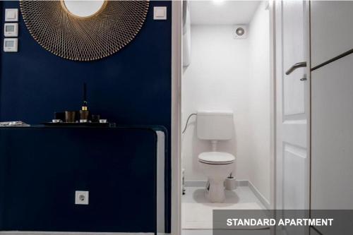 een badkamer met een toilet en een blauwe muur bij Savouir Bleu Suite near Danube in Boedapest