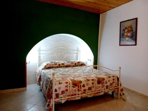 a bedroom with a bed in a green wall at Celebrity House in Marsala