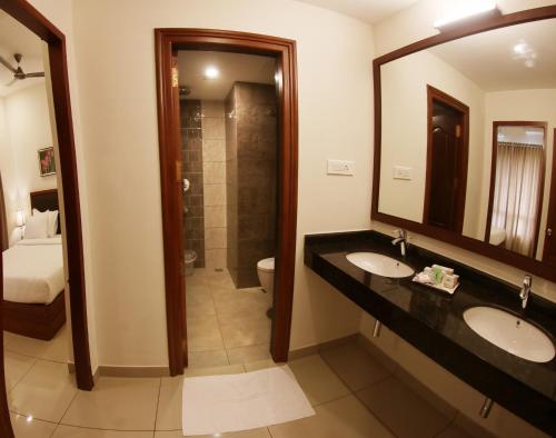 a bathroom with two sinks and a large mirror at Bhasuri Inn Guruvayoor in Guruvāyūr