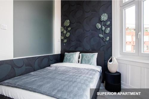 布達佩斯的住宿－BpR Agathé Elegant Suite with Parliament View，一间卧室配有一张带蓝色床头板的床和窗户