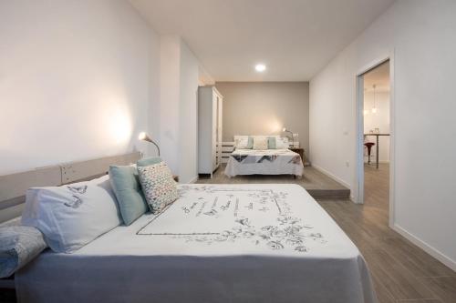 a bedroom with a large bed and a living room at Altea Puerto Playa in Altea