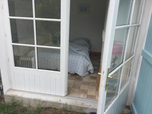 een deur naar een slaapkamer met een bed bij Maison 100 m plage, 2 kms du port in L'Ile d'Yeu