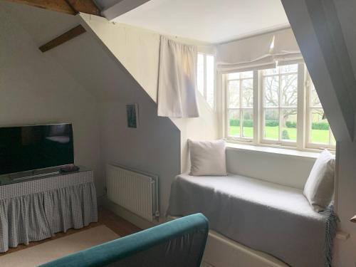 ein Wohnzimmer mit einem Sofa, einem TV und einem Fenster in der Unterkunft Dalton House Bed and Breakfast in Newcastle upon Tyne