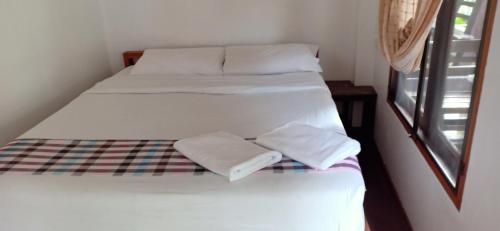 two beds in a room with white sheets and pillows at paibaansuan in Pai