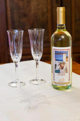 a bottle of wine and two wine glasses on a table at Antica Casa Balsari in Borgo Ticino