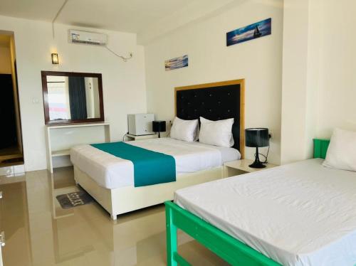 a hotel room with two beds and a window at One World Mirissa in Mirissa