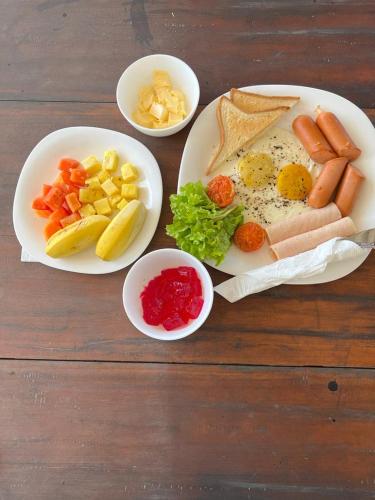 a table with two plates of food with eggs and vegetables at One World Mirissa in Mirissa