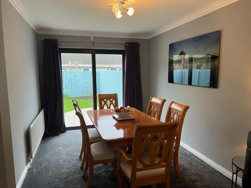 a dining room with a wooden table and chairs at Home from Home in Six Road Ends