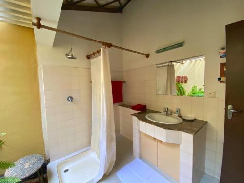 a bathroom with a sink and a shower and a toilet at Ging Oya Lodge in Waikkal