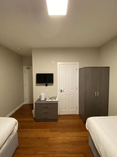 a hotel room with two beds and a television at Buckingham Hotel in High Wycombe
