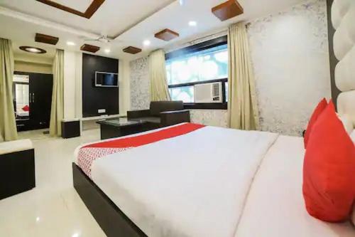 a bedroom with a large white bed with red pillows at HOTEL VEER BHUMI PALACE in Jhānsi