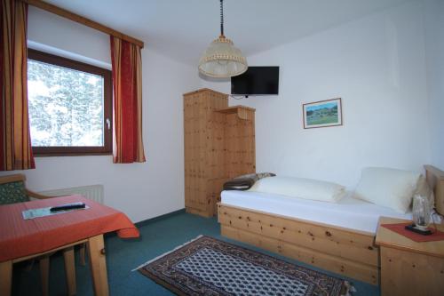 a small room with a bed and a window at Pension Hubertushof beim Römerbad in Bad Kleinkirchheim