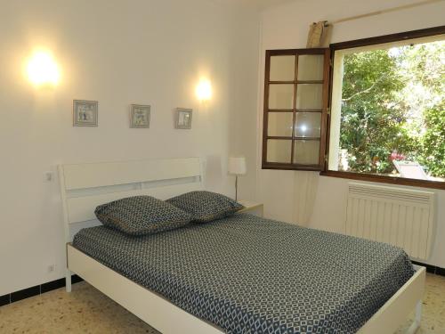 ein Schlafzimmer mit einem Bett mit zwei Kissen und einem Fenster in der Unterkunft maison proche mer in Saint-Raphaël