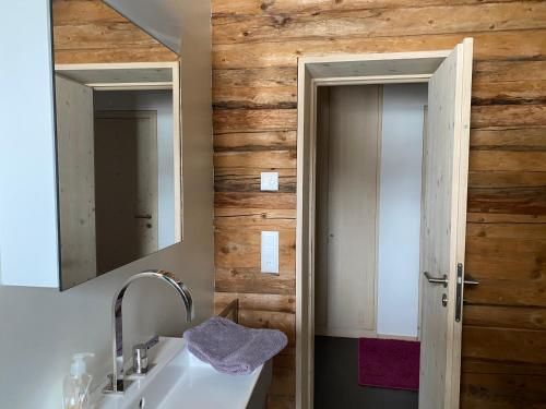 ein Bad mit einem Waschbecken und einem Spiegel in der Unterkunft Wohnung mit Charme im Künstlerviertel in der Villa Stailamar in Susch in Sur