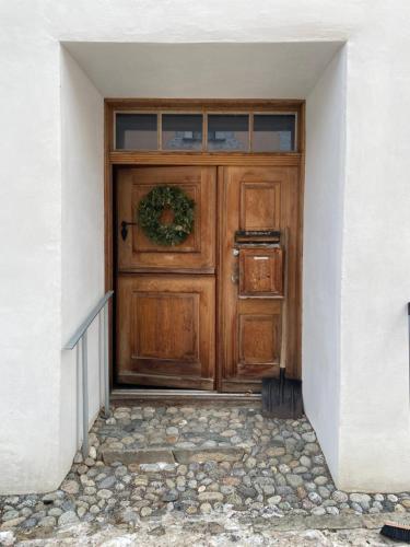 una porta di legno con una corona di fiori di Wohnung mit Charme im Künstlerviertel in der Villa Stailamar in Susch a Susch