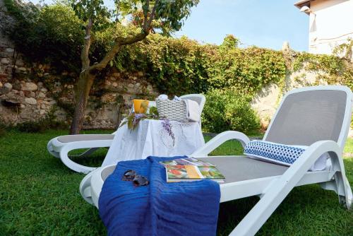 two chairs and a table with a blanket on the grass at Antica Casa Balsari in Borgo Ticino