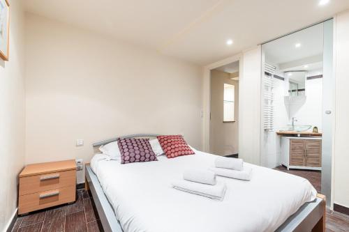 une chambre avec un grand lit blanc et un miroir dans l'établissement Atypical Cozy 1 Bdr Old Town, à Nice