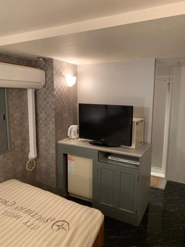 a room with a flat screen tv on a table at City Hotel Southern Cross in Tokyo