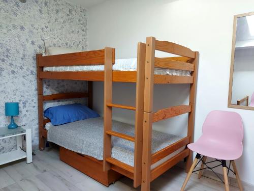 a bedroom with two bunk beds and a pink chair at Gite La Saubolle à Marciac in Marciac