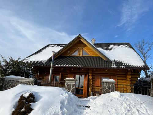 a log cabin with snow on the roof at Zrubová Chata Sylvester in Oravská Lesná