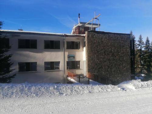 a building in the snow with snow around it at Chata - Dom Horskej služby Jasna in Demanovska Dolina