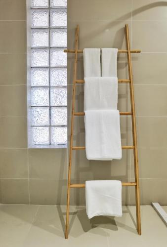 a towel rack in a bathroom with white towels at Riverside Retreat Hotel in Yangshuo