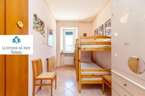 Una pequeña habitación con una litera y una silla. en LA TERRAZZA SUL MARE - NUMANA -, en Numana