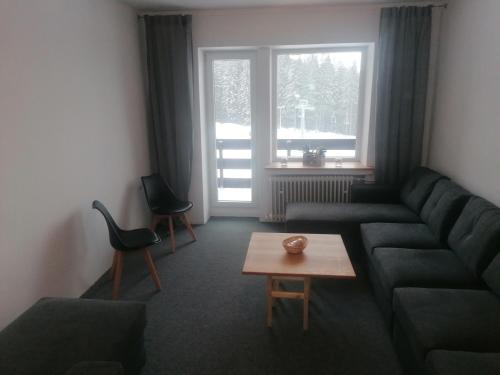 a living room with a couch and a table at Chata - Dom Horskej služby Jasna in Demanovska Dolina