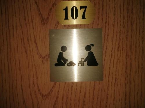 a sign on a wall with a woman playing with a child at Chata - Dom Horskej služby Jasna in Demanovska Dolina